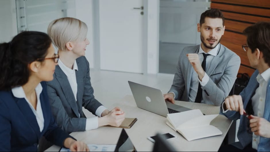 about us page example showing a professional team discussion around a conference table.