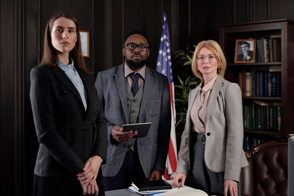 Three professionals from the Small Business Administration in a formal office setting with an American flag and bookshelf in the background.