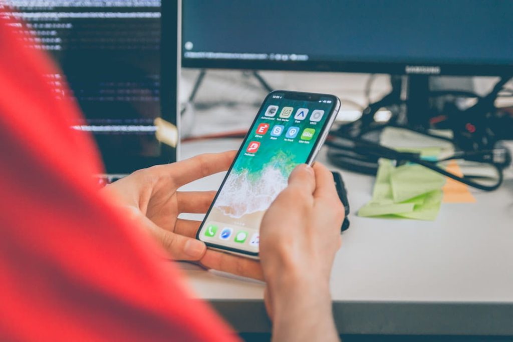 Smartphone and developer workspace illustrating mobile checks in a website launch checklist.