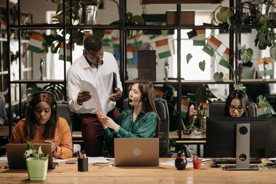 Customer support team collaborating around customer satisfaction survey questions and feedback review.