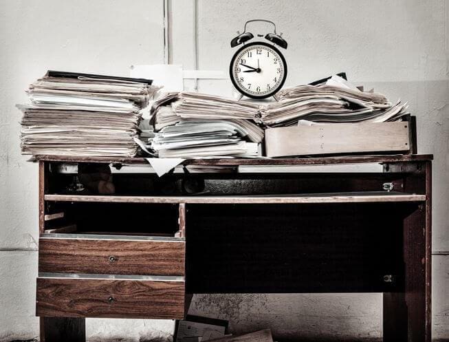 Desk Stacked With Paper Clutter