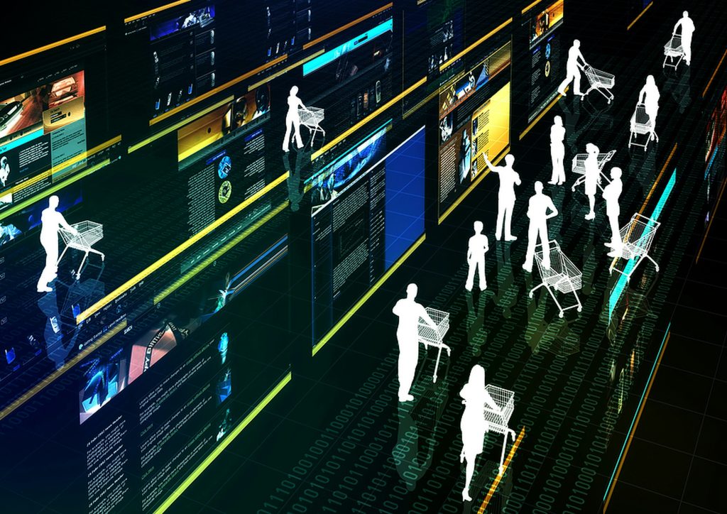 Futuristic digital marketplace with multiple glowing vertical screens arranged in aisles, displaying web content like cars, phones, and text. White silhouette figures, some pushing shopping carts, navigate the aisles on a dark, reflective floor with binary code. The scene has a dark blue and green color scheme with bright yellow and cyan accents, evoking a virtual e-commerce environment with ads for small business.