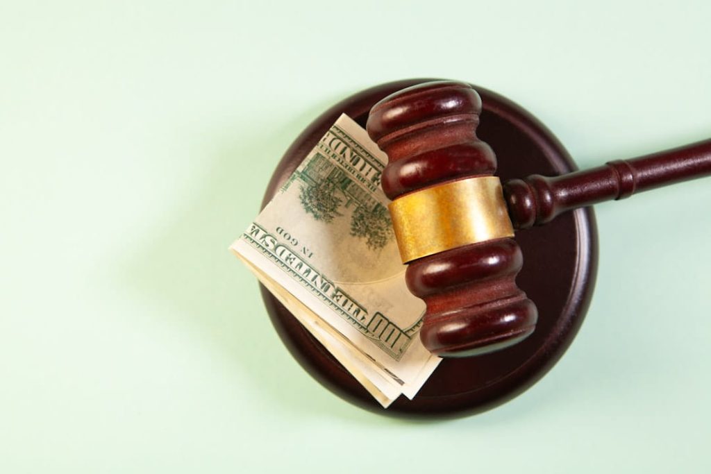 Wooden gavel resting on a folded $100 bill, symbolizing the legal weight of a non disclosure agreement template.