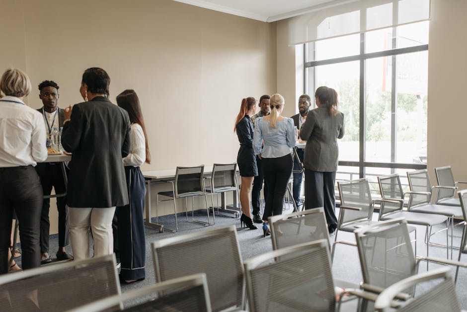 Professionals on a professional networking platform networking in a modern conference room with large windows and seating.