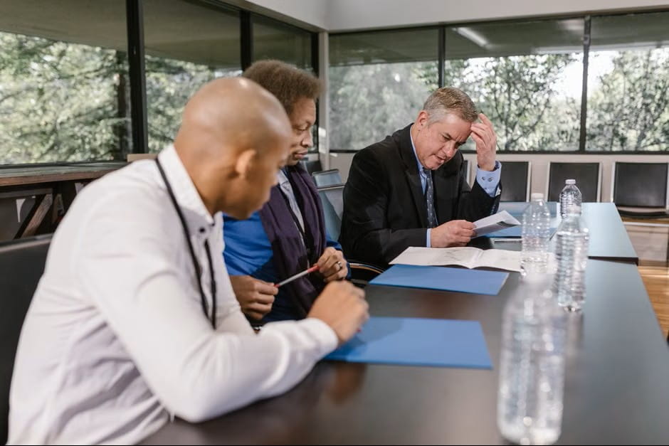 Small business health plans meeting scene with business professionals reviewing documents in a conference room.