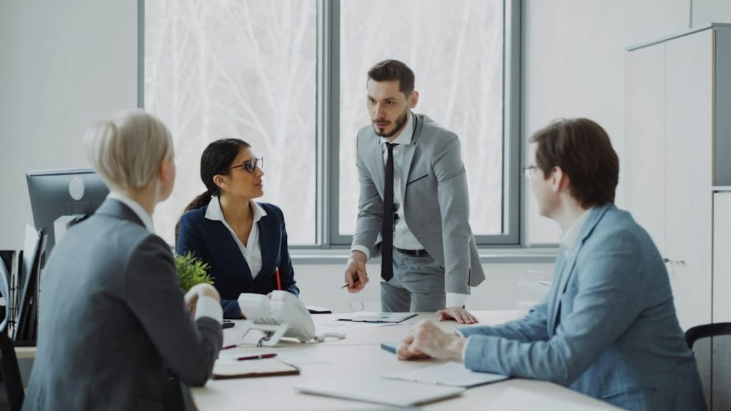 small business planner team meeting with business leader presenting at conference table.